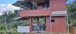 a house on the side of a hill at cabaña Carol in Rio Celeste