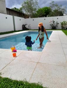 una mujer y un niño jugando en una piscina en Departamento para 5 personas con pileta, en Villa Gesell