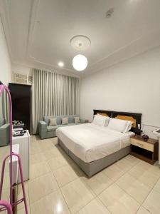 een slaapkamer met een groot bed en een bank bij كيان الين البديع in Abha +24 foto's