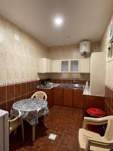 een keuken met een tafel, stoelen en een spoelbak bij كيان الين البديع in Abha