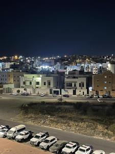 een parkeerplaats met auto's geparkeerd voor een stad bij كيان الين البديع in Abha
