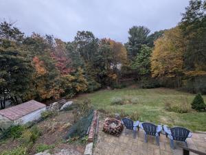 a group of chairs sitting around a fire in a yard at Quiet, Convenient Studio Andover Merrimack Valley - Long Stays Only in Andover