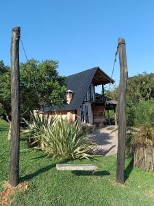ein Haus mit zwei Holzpfählen davor in der Unterkunft Chalés Refúgio nas montanhas in Guaratuba
