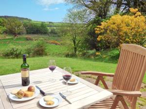 einen Picknicktisch mit einer Flasche Wein und Gläsern in der Unterkunft Little Boreland in Gatehouse of Fleet