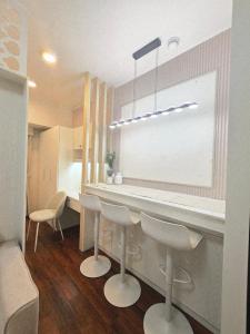 a kitchen with a counter and chairs in a room at Condo Hotel Walking Abreeza Mall and Near SM Lanang in Davao City