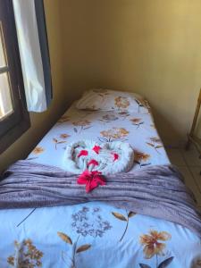a bed with two towels and flowers on it at Villa da Apa in Japaratinga