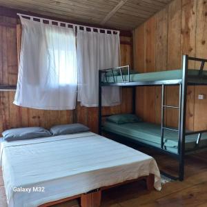 two bunk beds in a room with a window at Chalés Vitória in Trindade