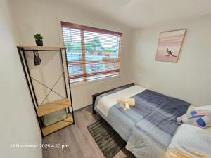 a bedroom with a bed with two teddy bears on it at Manuki Tiny Retreat - Private stay Christchurch in Christchurch