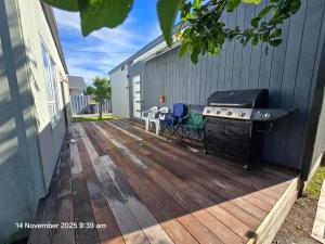 a deck with a grill and a barbecue on a house at Manuki Tiny Retreat - Private stay Christchurch in Christchurch