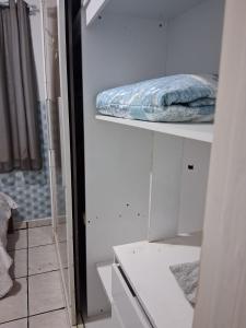 a room with white shelves and a pillow on it at Hostel Mi Casa Su Casa 1 in Poços de Caldas