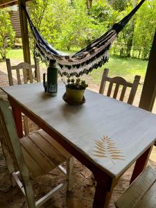 ein Tisch mit einer Flasche Wein und einer Hängematte in der Unterkunft Casa Nani in Ituzaingó + 2 Fotos