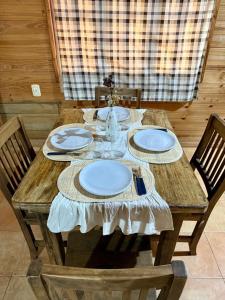 einen Holztisch mit Tellern auf einem Zimmer in der Unterkunft Casa Nani in Ituzaingó