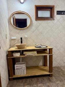 ein Badezimmer mit einem Holztisch und einem Spiegel in der Unterkunft Casa Nani in Ituzaingó
