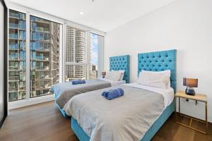 deux lits dans une chambre avec une grande fenêtre dans l'établissement SOP 27 Stylish and Cozy 2 Bedroom Apartment, à Sydney