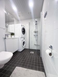 ein Badezimmer mit Toilette, Waschbecken und Waschmaschine in der Unterkunft Penthouse in the Oulu center in Oulu