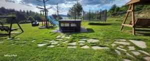 a park with a playground with a swing set at Къщи за гости Илиеви , Цигов Чарк in Batak