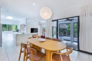 ein Esszimmer und eine Küche mit Tisch und Stühlen in der Unterkunft Stylish Family Retreat in Varsity by Housemark Escapes in Gold Coast