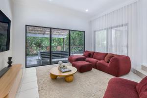 ein Wohnzimmer mit einem roten Sofa und einem Tisch in der Unterkunft Stylish Family Retreat in Varsity by Housemark Escapes in Gold Coast