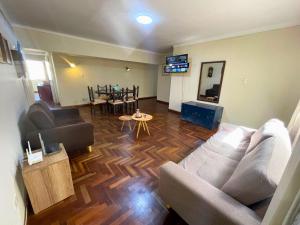 ein Wohnzimmer mit Sofa und Tisch in der Unterkunft Apartamento en Tacna Amplio, Lindo y Céntrico in Tacna