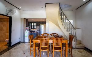 een keuken en eetkamer met een houten tafel en stoelen bij Tranquility 3 Bed villa in saba with garden view in Saba