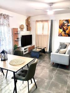 ein Wohnzimmer mit Tisch und Fernseher in der Unterkunft Tilys house in Capesterre-Belle-Eau + 13 Fotos