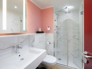 a bathroom with a white sink and a shower at Grand Hotel des Brotteaux Lyon Ctre - Handwritten Collection in Lyon