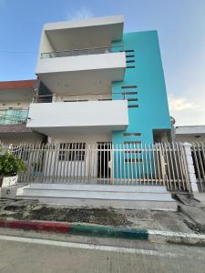 ein Gebäude mit einem weißen Zaun davor in der Unterkunft Apartamentos Mila in Guayabal