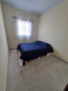 een slaapkamer met een blauw bed en een raam bij vacation home Bonito PE in Bonito