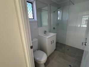 a white bathroom with a toilet and a shower at Kin Kora Village in Gladstone +15 photos