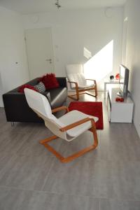 - un salon avec une chaise blanche et un canapé dans l'établissement La boîte rouge, à Stavelot