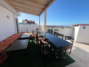 a room with tables and chairs on a roof at Azurf - Imsouane Surf House in Imsouane