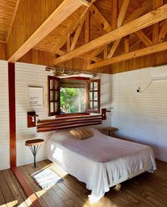 ein Schlafzimmer mit einem großen Bett mit Fenster in der Unterkunft Cabañas Parana Ranch in Ituzaingó