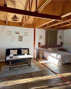 ein Schlafzimmer mit einem Bett und einer Bank in einem Zimmer in der Unterkunft Cabañas Parana Ranch in Ituzaingó + 10 Fotos