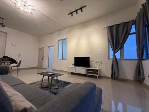 ein Wohnzimmer mit Sofa und Fernseher in der Unterkunft New Cozy Comfort StayWithStyle Centra Residences at Dato ONN 3 BR 4 Bath Spacious in Johor Bahru