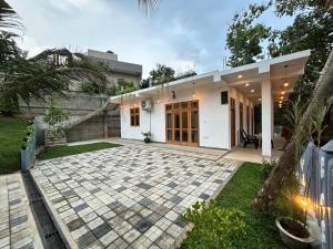 ein Haus mit einer Steinterrasse davor in der Unterkunft Villa Tesh Hiriketiya in Dikwella