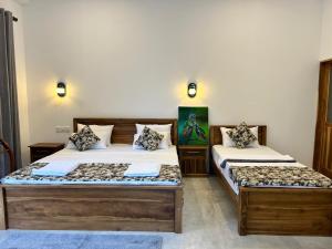 zwei Betten in einem Zweibettzimmer in der Unterkunft Villa Tesh Hiriketiya in Dikwella
