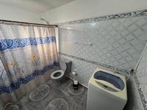 um banheiro com vaso sanitário e cortina de chuveiro em El CHANFLE em Punta Del Diablo mais 19 fotografias