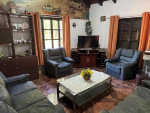 uma sala de estar com sofás, uma mesa e uma televisão em El CHANFLE em Punta Del Diablo