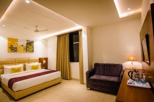 a hotel room with a bed and a chair at HOTEL TEN SQUARE - 5 Minutes from The Taj Mahal in Agra