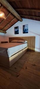 łóżko w pokoju z dwoma zdjęciami na ścianie w obiekcie Flat Manaí 02 w mieście Maraú