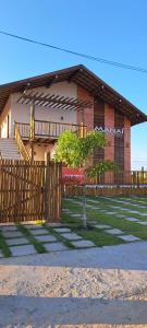 dom z drzewem przed płotem w obiekcie Flat Manaí 02 w mieście Maraú