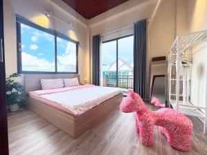 - une chambre avec un lit rose et une grande fenêtre dans l'établissement Kem house 1- Venuestay, à Da Thien