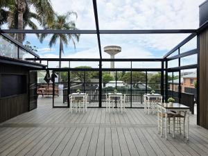 シドニーにあるRiverview Hotel Tempeのデッキにテーブルと椅子が置かれたパティオ