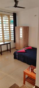 une chambre avec un lit, une table et des fenêtres dans l'établissement Ludu guest house, à Arambol