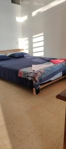 - un lit avec une couette bleue dans l'établissement Ludu guest house, à Arambol