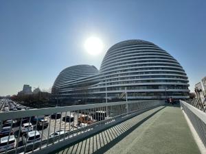 two domed buildings with cars parked in a parking lot at New Jinshan Apartment in Beijing