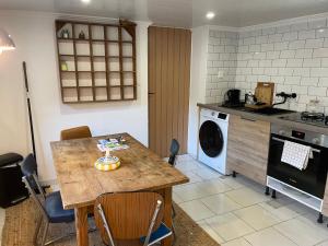 a kitchen with a table and a washing machine at Gîte de charme calme au cœur du Perche, proche Le Mans - FR-1-410-478 in Courgains +14 photos