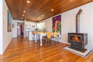 ein Wohnzimmer mit einem Kamin und einem Tisch mit Stühlen in der Unterkunft The Shack in Seal Rocks