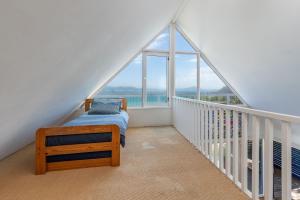 Schlafzimmer mit einem Bett und einem Balkon mit Fenstern in der Unterkunft The Shack in Seal Rocks