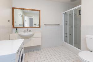 ein weißes Badezimmer mit Waschbecken und Dusche in der Unterkunft The Shack in Seal Rocks